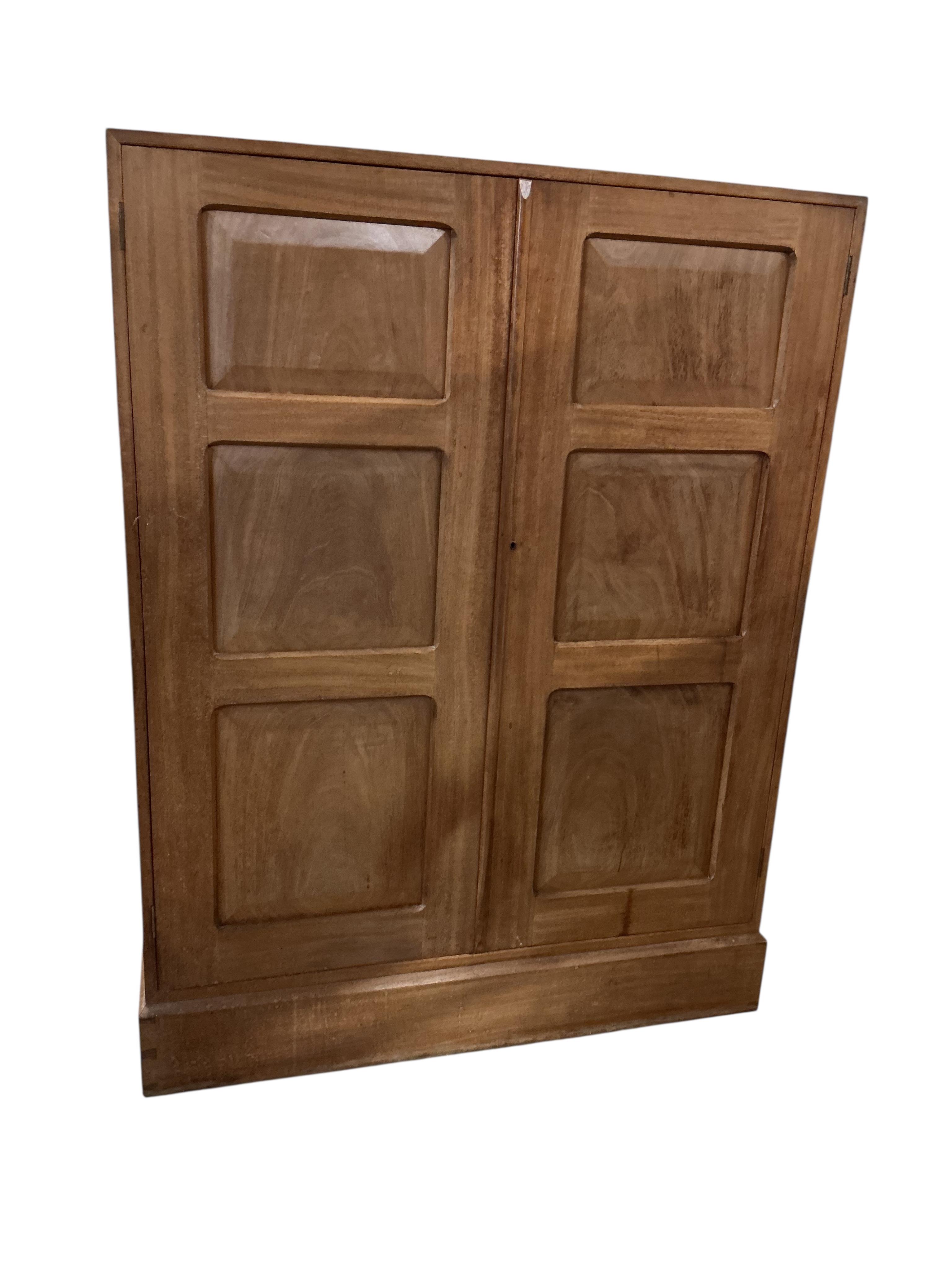 Manner of Gordon Russell, a mid century teak two door compactum, width 99cm, depth 44cm, height 130cm